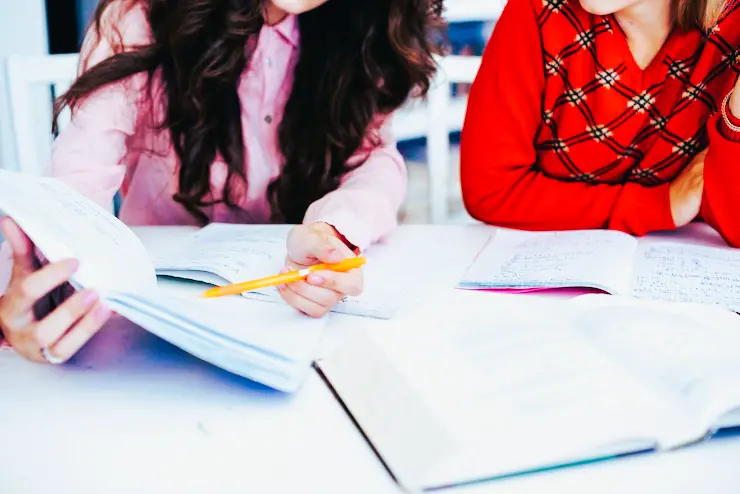 dos estudiantes estudiando cuadernillos icfes